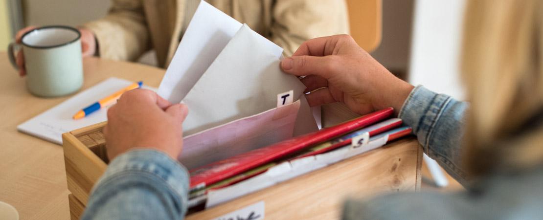 Frau mit Karteikasten im Vordergrund, Klientin im Hintergrund